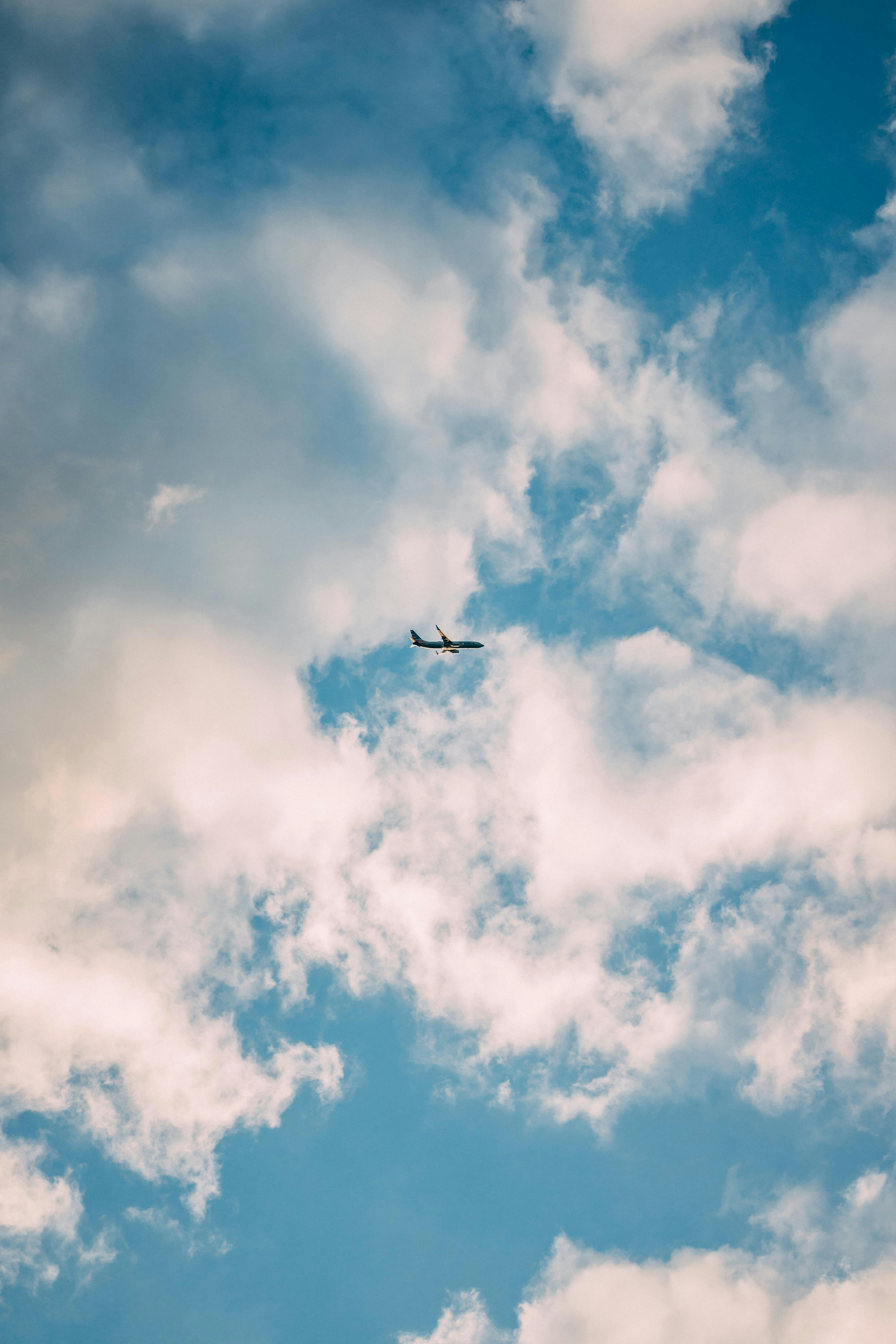 airplane under white clouds